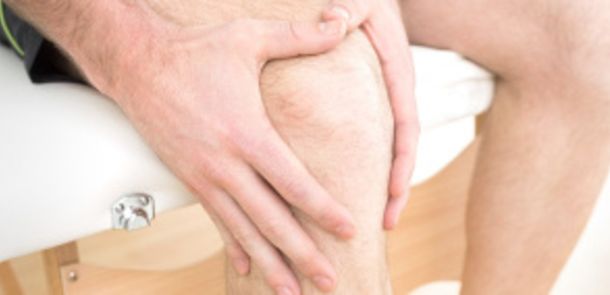 bestellt am 14.08.2014 für den Relaunch der Corporate Webseite;    Close-up mid section of a young man with his hands on a painful knee while sitting on examination table