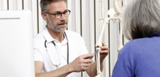 Ein Arzt erklärt einer Patientin an einem Modell-Skelett den Aufbau des Kniegelenks. Ein Arzt erklärt einer Patientin an einem Modell-Skelett den Aufbau des Kniegelenks.